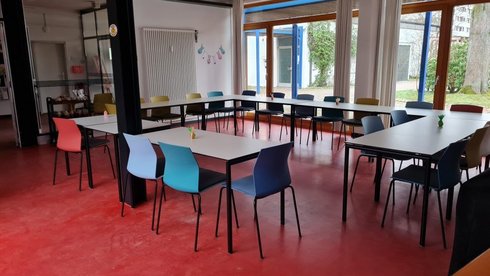 Treffpunkt Bergedorf Innenansicht: Raum mit mehreren bestuhlten Tischen, im Quadrat angeordnet 