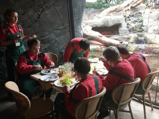 Sechs Personen essen gemeinsam an einem Tisch