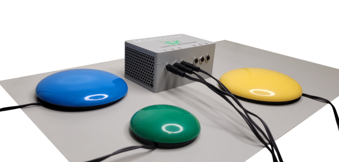 Auf einem Tisch liegt der Mitmischer. Ein grauer Kasten mit bunten Buzzern.