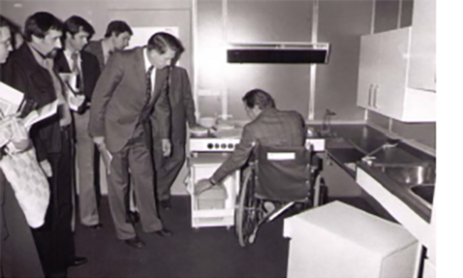 Profis inspizieren einen Herd Ausstellung mit Rollstuhl gerechter Küche