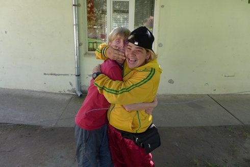 zwei Menschen umarmen sich vor einer Hauswand